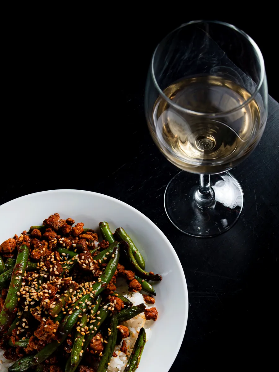 Plated dish with a glass of white wine, food photography by Aki