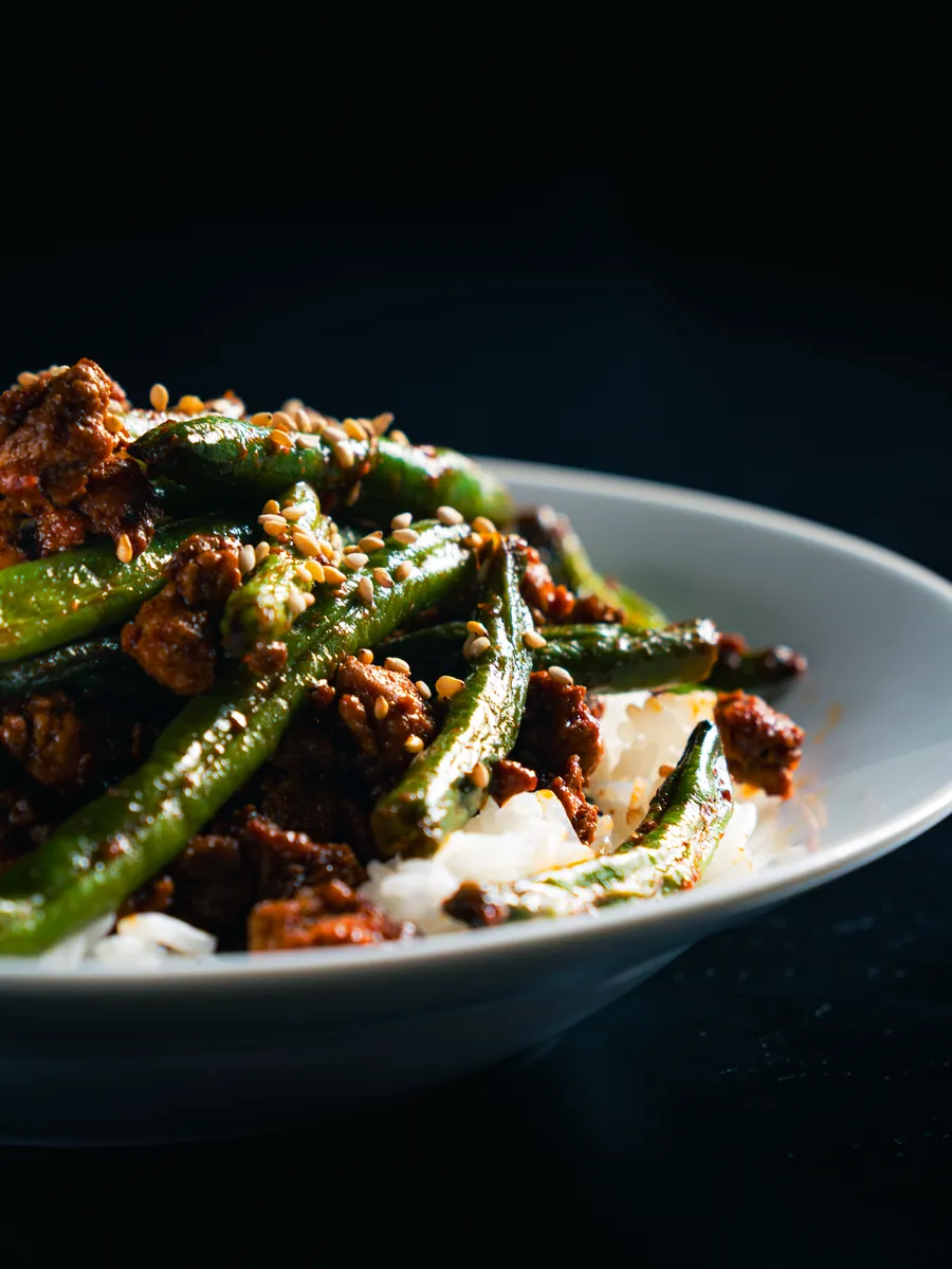 Green beans and mince on a dark background, food photography by Aki